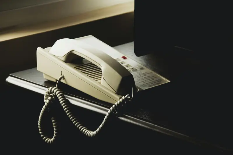 Un combiné téléphonique posé sur un bureau.