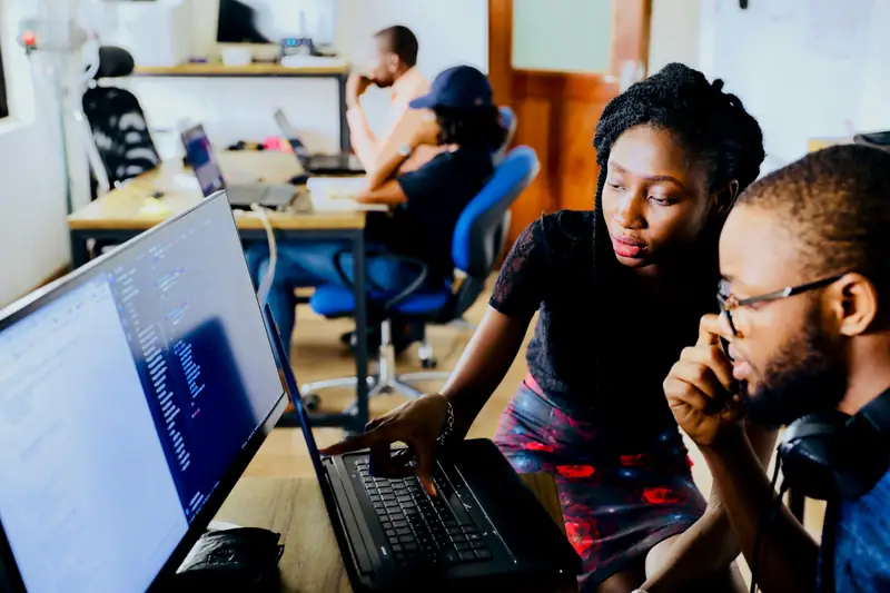 Trois collègues à leurs postes de travail, dans un plateau ouvert.