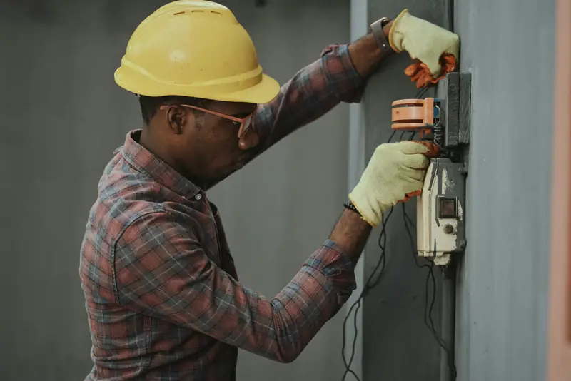 Un électricien sur un tableau de répartition.